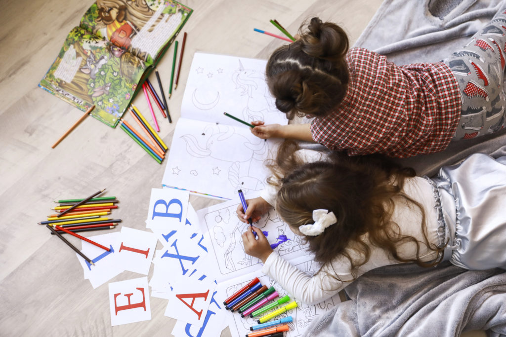 tiny girls which are drawing in the coloring 